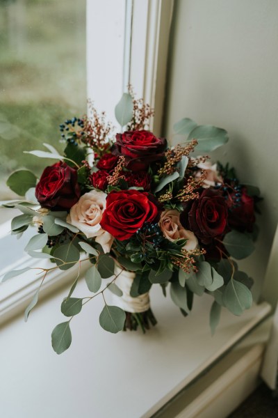 red roses flowers bouquet resting on windowsill