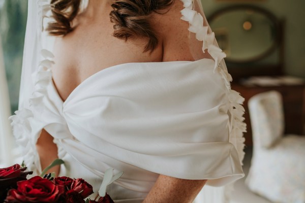 close up of bridals gown dress puffy sleeves veil detail as she holds bouquet