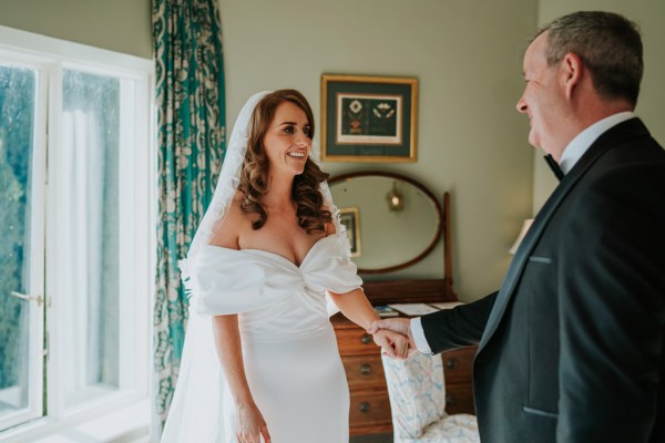 father of the bride walks into room they hold hands