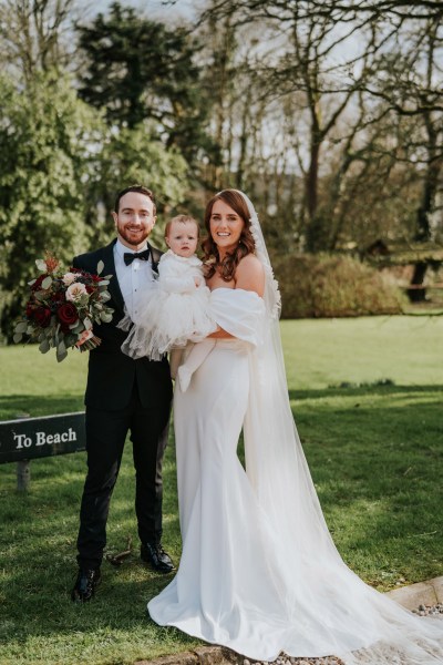 bride groom and little babygirl wearing white dress they smile