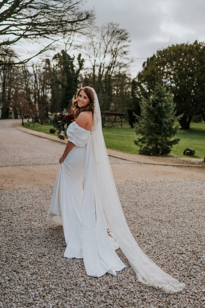 bride stands in the courtyard pathway to wedding venue