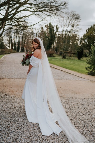 bride stands in the courtyard pathway to wedding venue