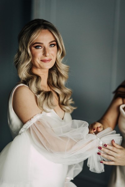 bride gets ready and help from mother or bridesmaids puffy lace see-through lace bridal gown dress