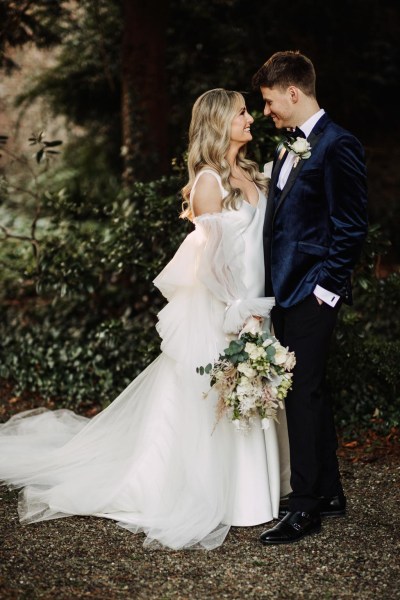 groom reacts to bride as they face each other in garden