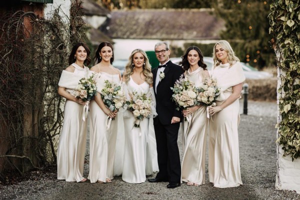 bride father and bridesmaids all pose in a row