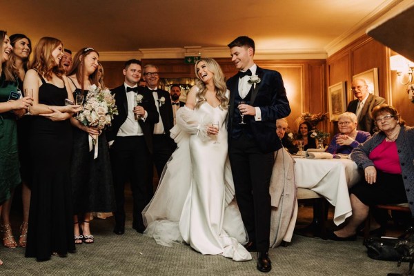 bride and groom enter ballroom with guests clapping