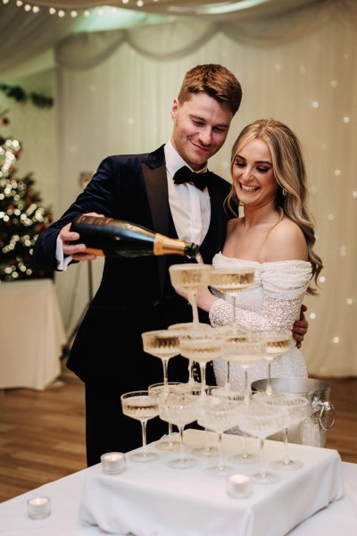 champagne fountain bride and groom smile