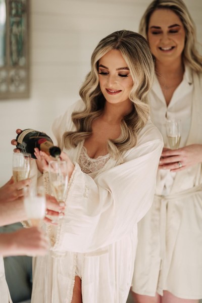 bride getting ready pouring champagne into glass