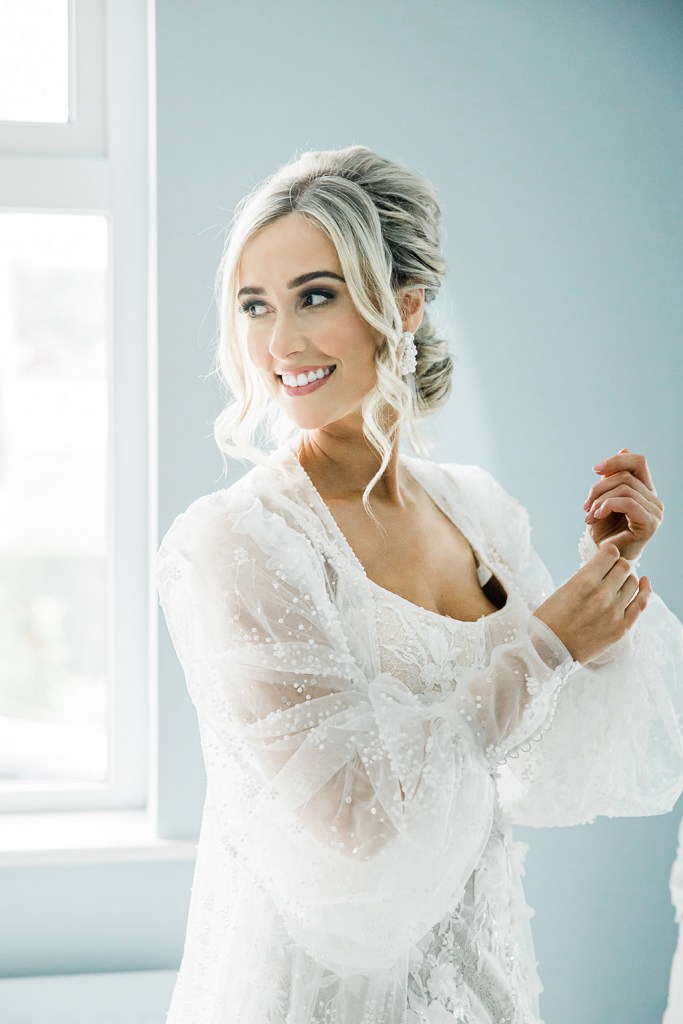 bride fixes up her sleeves on dress