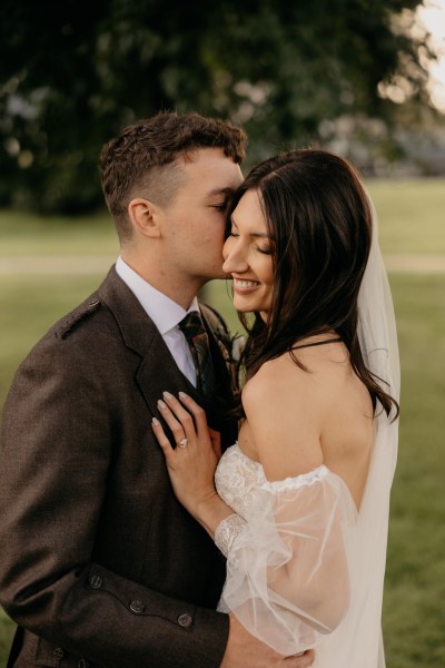 Groom kisses bride wearing floral embroidery dress during island wedding